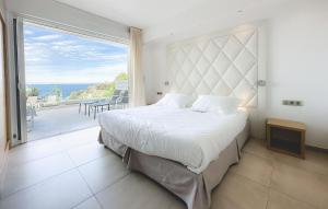 a bedroom with a large bed and a large window at Hotel Villa R in Calvi