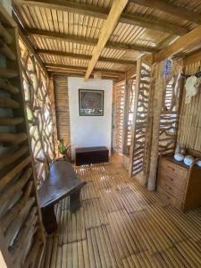 Habitación con banco y suelo de madera. en Balay Asiano Cabin, en Puerto Princesa City