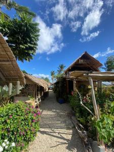 a group of huts with flowers and plants at Balay Asiano Cabin in Puerto Princesa City