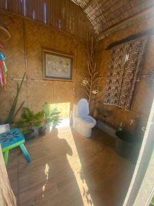 a bathroom with a toilet and plants in it at Uncle Jo's Beach Cabin Balay Asiano in Puerto Princesa City