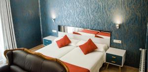 a bedroom with a large bed with red pillows at Hotel Jaqués in Jaca