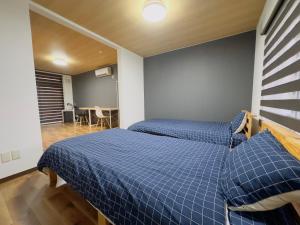 two beds in a room with blue sheets at リノベーション済み室内新築　Service Apartment Sapporoザ・ハウス4LDK86㎡ in Sapporo