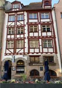 a building with blue umbrellas in front of it at Zur Baumwolle in Nuremberg