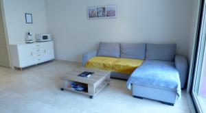 a living room with a couch and a table at Mer, plages, piscine, paysages ydilliques:LE REVE! in Théoule-sur-Mer