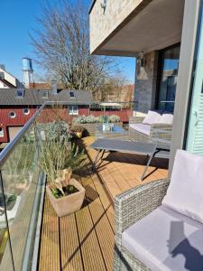 a deck with a table and chairs on a balcony at Moderne Penthouse Wohnung in Schleswig