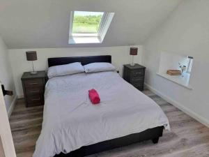 Un dormitorio con una cama con una bolsa roja. en Eanymore Farm Cottage en Donegal