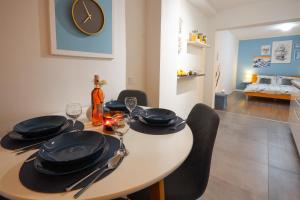 a dining room table with chairs and a clock on the wall at Apartment Blue in Poreč