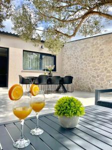 Dois copos de sumo de laranja sentados numa mesa. em Villa Grioni, beach front villa with jacuzzi em Novalja