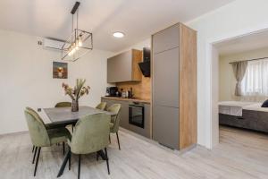 a kitchen and dining room with a table and chairs at Villa Grioni, beach front villa with jacuzzi in Novalja