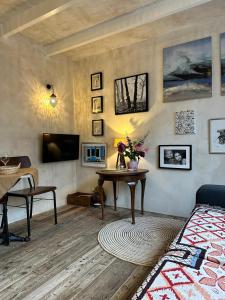 een woonkamer met een bed, een tafel en een televisie bij Cottage Rose in Bergen