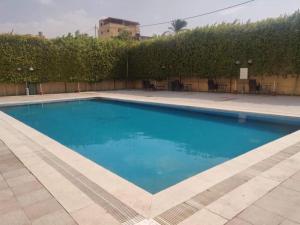 a swimming pool with blue water in a yard at Dead sea 2 bedroom apartment in Astana ,swemeh Jordan in Sowayma
