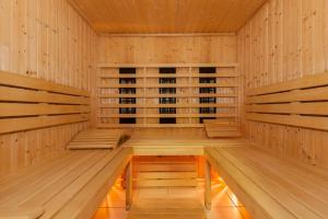 uma sauna de madeira com bancos de madeira num quarto em Kamienica Parkowa em Dąbki