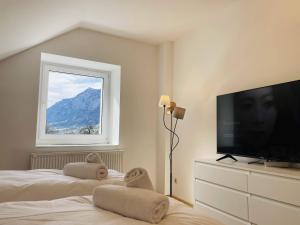 a bedroom with a flat screen tv and a window at homy Alpenlodge in Innerbraz