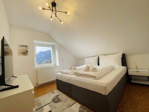 a bedroom with a bed with white sheets and a window at homy Alpenlodge in Innerbraz