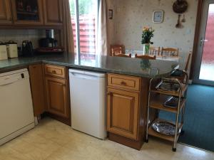 a kitchen with a counter top and a dishwasher at Ardgarry Holiday House in Inverness +20 photos