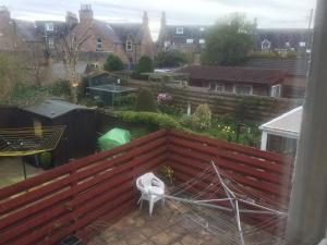 a view of a yard with a fence and a white chair at Ardgarry Holiday House in Inverness