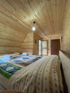 a bedroom with two beds in a log cabin at Guest House Rrashkadoli in Theth