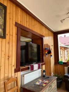 Ana-Dragusana في Drăguş: غرفة معيشة مع تلفزيون وطاولة مع طاولة سيد