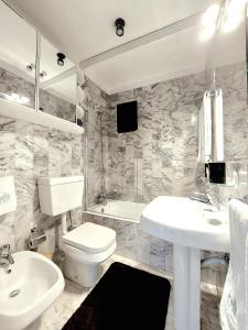 La salle de bains est pourvue d'un lavabo, de toilettes et d'une baignoire. dans l'établissement Espinho Guesthouse - Sea View Apartment, à Espinho