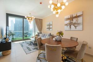 Prestige Living 1BR with Full Burj Khalifa View by Auberge في دبي: غرفة معيشة مع طاولة وأريكة