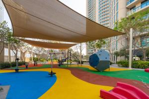 a playground in a city with a large umbrella at Prestige Living 1BR with Full Burj Khalifa View by Auberge in Dubai