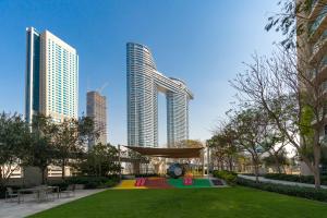 un parc au milieu d'une ville avec de grands bâtiments dans l'établissement Prestige Living 1BR with Full Burj Khalifa View by Auberge, à Dubaï
