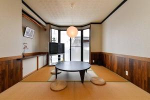a living room with a table and a tv at 貸切民泊 志ろきや in Katsuyama