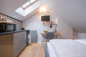 um quarto com uma cama e uma cozinha com um micro-ondas em Lollo Residence - Lollo Luxury em Vilnius