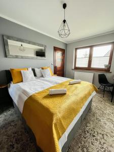 um quarto com uma cama grande e um cobertor amarelo em Sierockie Szczyty em Zakopane