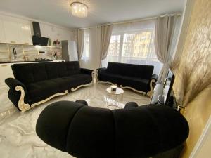 un soggiorno con divano nero e tavolo di Luxury Apartament & Parking a Floreşti