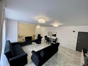 un soggiorno con divano, sedie e tavolo di Luxury Apartament & Parking a Floreşti