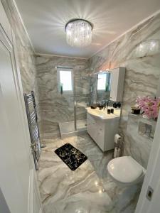 bagno con servizi igienici bianchi e lavandino di Luxury Apartament & Parking a Floreşti