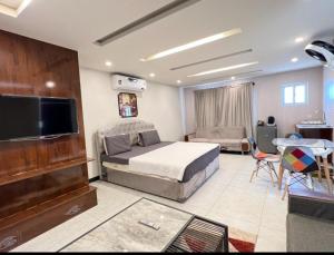 拉瓦爾品第的住宿－Pine Apartments Penthouse Bahria ISL，一间卧室配有一张床、一台电视和一张桌子