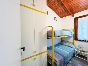 1 dormitorio con literas y ventana en -EXCLUSIVE PRIVATE VILLA- Villasimius, en Villasimius