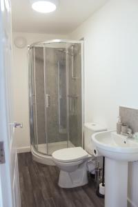 a bathroom with a shower and a toilet and a sink at Homely 1Bed Apt with Transport Links to CC in Heywood