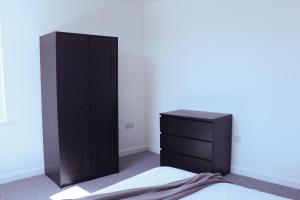 a bedroom with a black dresser and a black cabinet at Homely 1Bed Apt with Transport Links to CC in Heywood