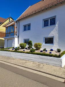 a white house with a garden in front of it at Ferienwohnung galina in Rockenhausen
