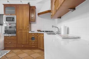 a kitchen with wooden cabinets and a white counter top at Apartament Cisza in Rabka