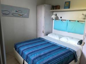 een slaapkamer met een bed met een blauw hoofdeinde bij "L'olivadou" ST JEAN CAP FERRAT in Saint-Jean-Cap-Ferrat