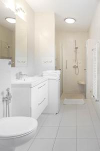 a white bathroom with a sink and a shower at Apartament Cisza in Rabka-Zdrój