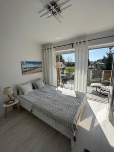 a bedroom with a bed and a large window at Apartamenty Dolce Vita in Ostrowo +163 photos