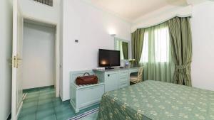 a hotel room with a bed and a flat screen tv at Hotel Santa Caterina in Palinuro