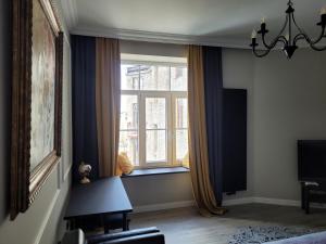 a room with a window with curtains and a chair at Apartament Danoe in Łódź