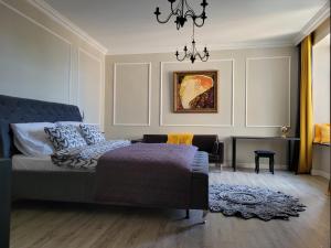 1 dormitorio con cama y lámpara de araña en Apartament Danoe, en Łódź