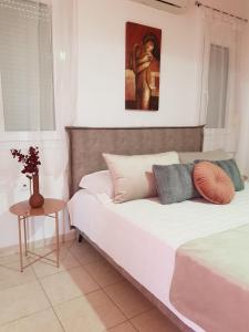 1 dormitorio con 1 cama y una pintura en la pared en Theti Apartment, en Faliraki
