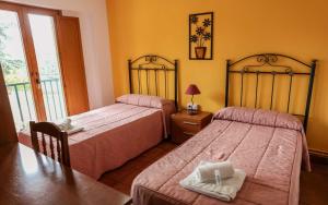 波托馬林的住宿－Pensión Boavista，一间卧室设有两张床、一张桌子和一个窗口