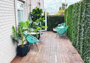 een patio met 2 stoelen, een tafel en planten bij Hobart Avenue Apartments The Retreat in Hobart