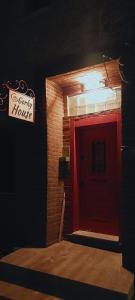 GorkyHouseUrla في Ildır: باب احمر في مبنى من الطوب مع وجود لافته