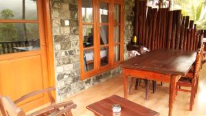 a dining room with a wooden table and chairs at Marvellous Inn in Ella