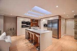 a large kitchen with a counter and a refrigerator at Large villa, walk to the beach in Cape Town